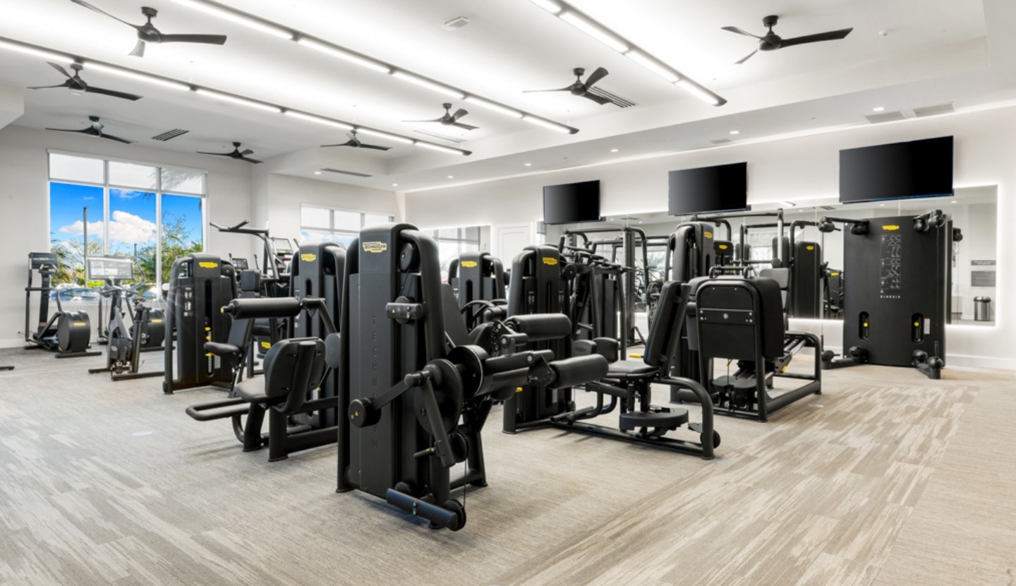 The fitness center at Esplanade, rows of cardio and strength equipment in a bright, window-lined room
