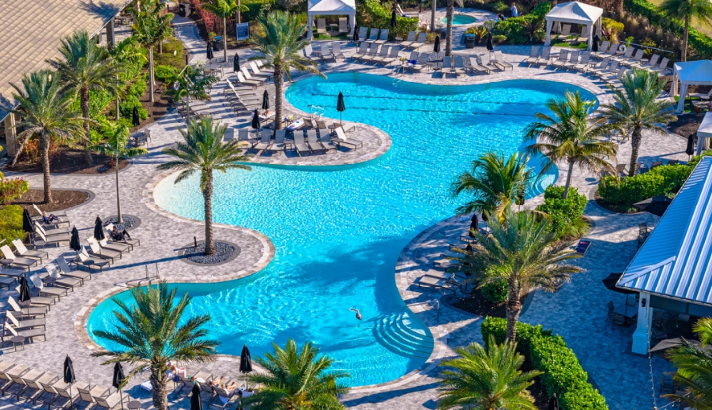Aerial view of the resort-style zero-entry pool at Esplanade, ringed by palms, lounge chairs and cabanas